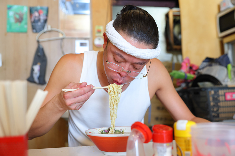 ラーメン健太の客席でご自身で作ったらーめんを食す横尾健太さん